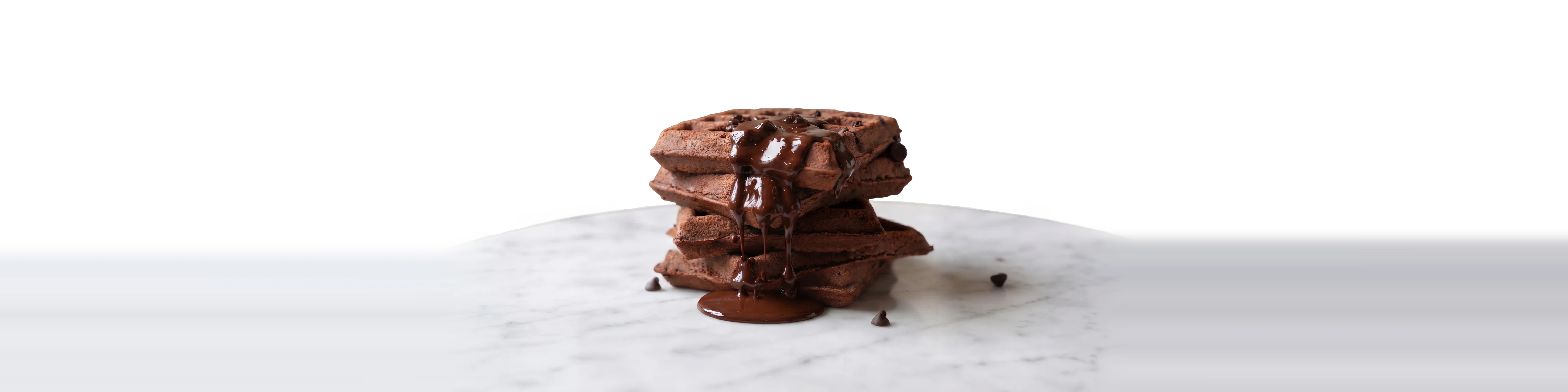 Torre de waffles de chocolate sobre una mesa de mármol